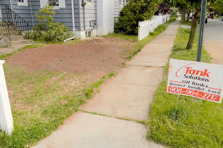 An image of a residential property with a Tank Solutions sign in front of it used to depict Tank Solution's trusted soil remediation service.