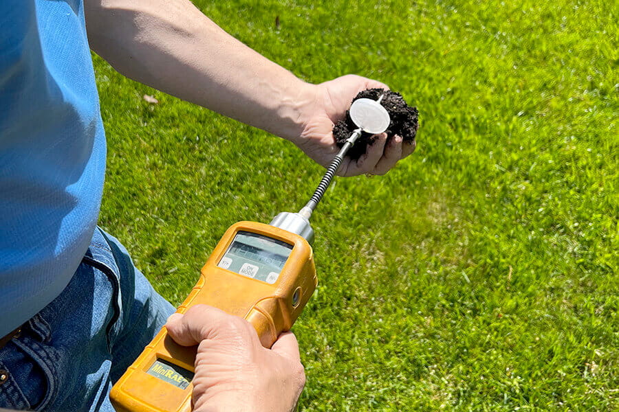 An image of a man completing soil sampling using a soil sampling tool used to depict Tank Solution's trusted soil sampling service.